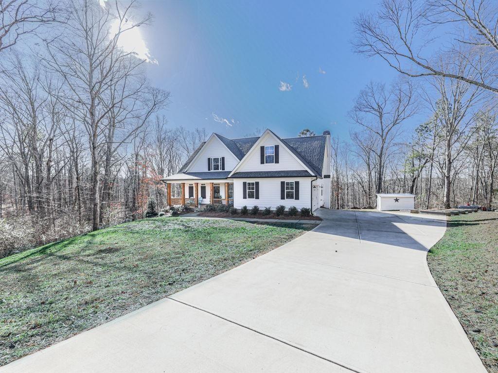 a front view of a house with yard porch and tree