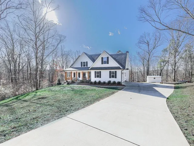a front view of a house with yard porch and tree
