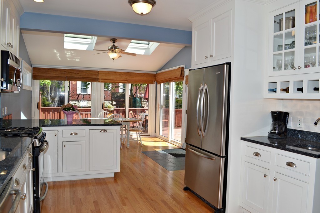 10 Caltha Road Boston, MA 02135 - Photo 10 of 30 a kitchen with stainless steel appliances a refrigerator a stove a sink dishwasher and white cabinets with wooden floor