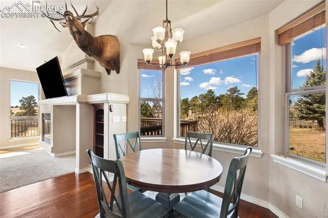 a view of a dining room with furniture a chandelier and wooden floor