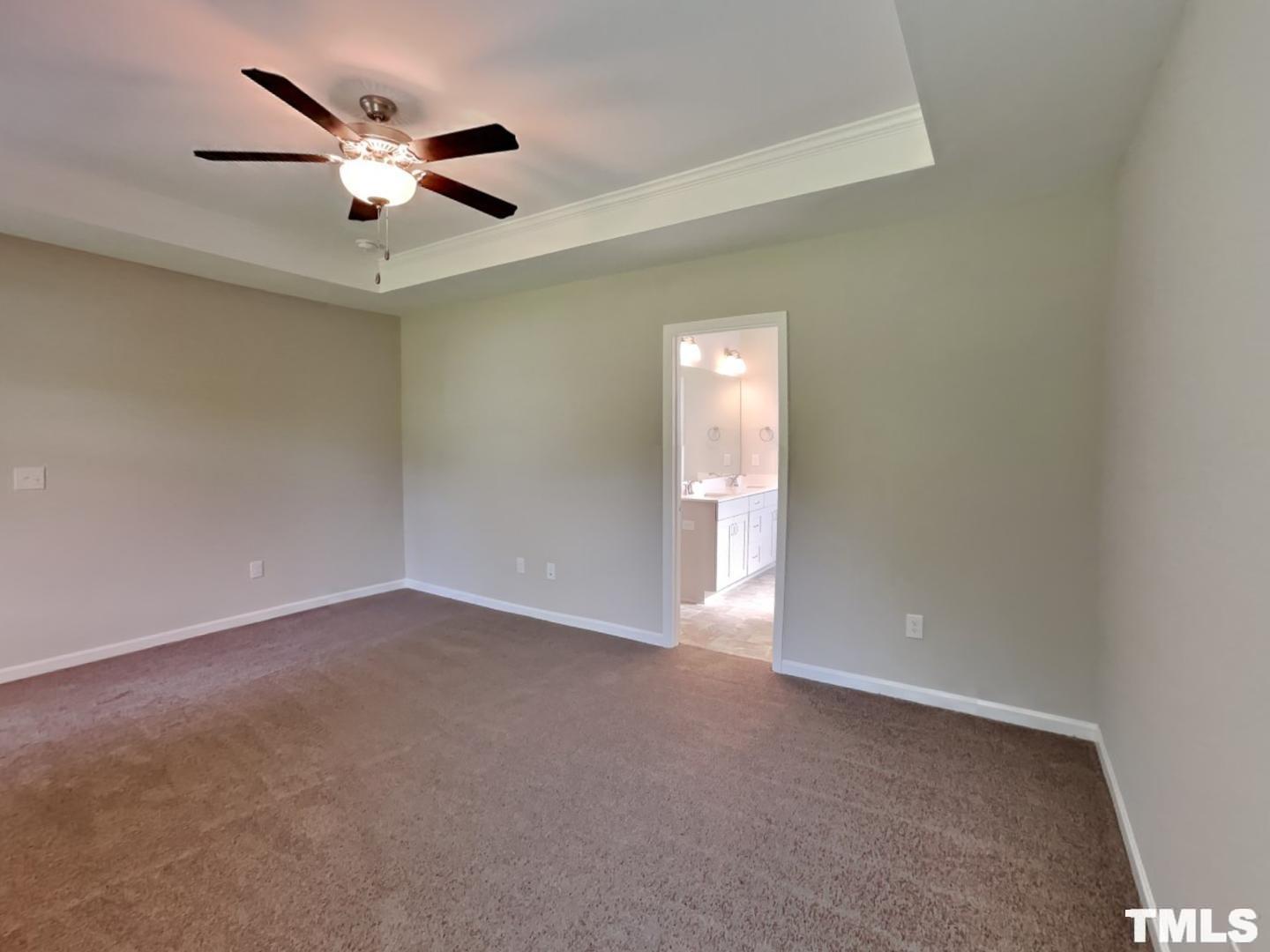 106 Two Daughters Streme Smithfield, NC 27577 - Photo 4 of 16 an empty room with a chandelier fan and windows
