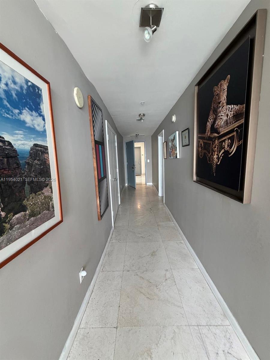 601 Northeast 36th Street, Unit 1112 Miami, FL 33137 - Photo 13 of 32 a view of a hallway with paintings on the wall