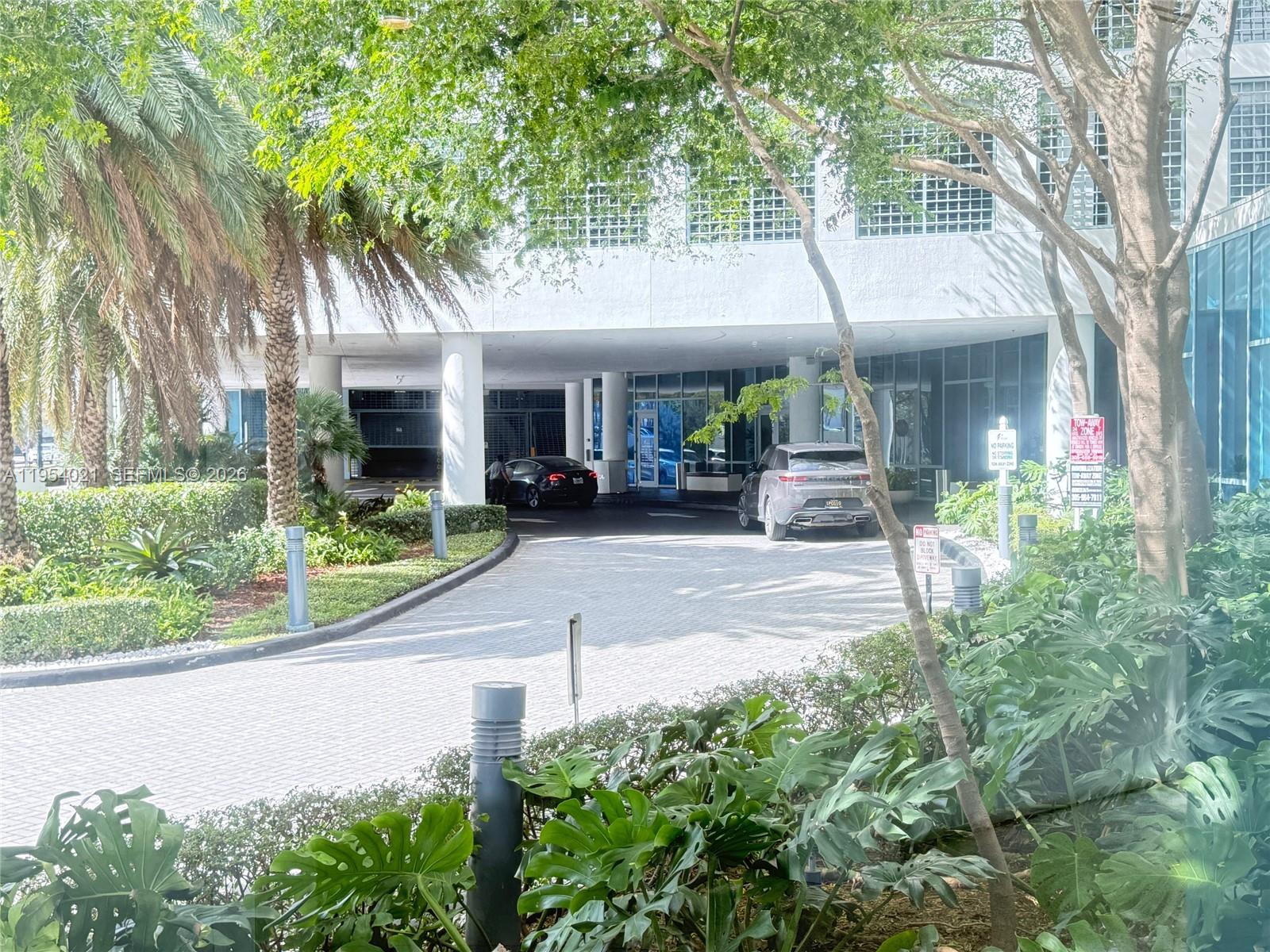 601 Northeast 36th Street, Unit 1112 Miami, FL 33137 - Photo 24 of 32 front view of a house with a yard and potted plants