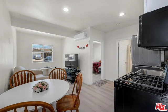 a kitchen with stainless steel appliances granite countertop a stove a sink dishwasher a dining table and chairs with wooden floor