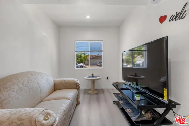 a living room with furniture a flat screen tv and a window
