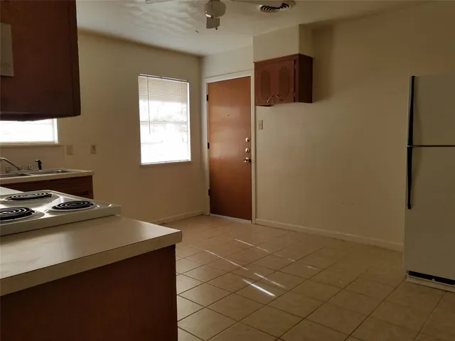 a kitchen with a sink a refrigerator and cabinets