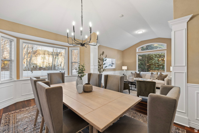 6208 West Bull River Road Highland, UT 84003 - Photo 9 of 90 Dining area featuring a contemporary chandelier, bay windows with white blinds, dark wood-finish flooring, and white wainscoting