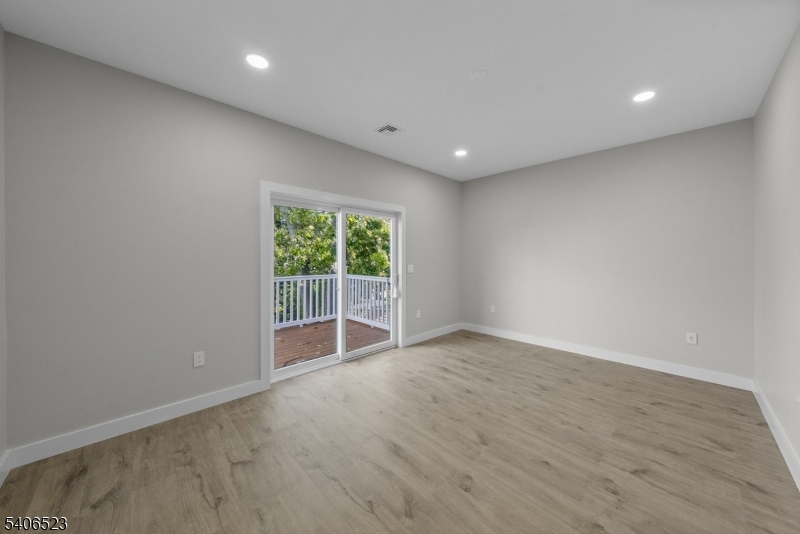 404 Washington Street Perth Amboy, NJ 08861 - Photo 7 of 45 a view of an empty room with wooden floor and a window