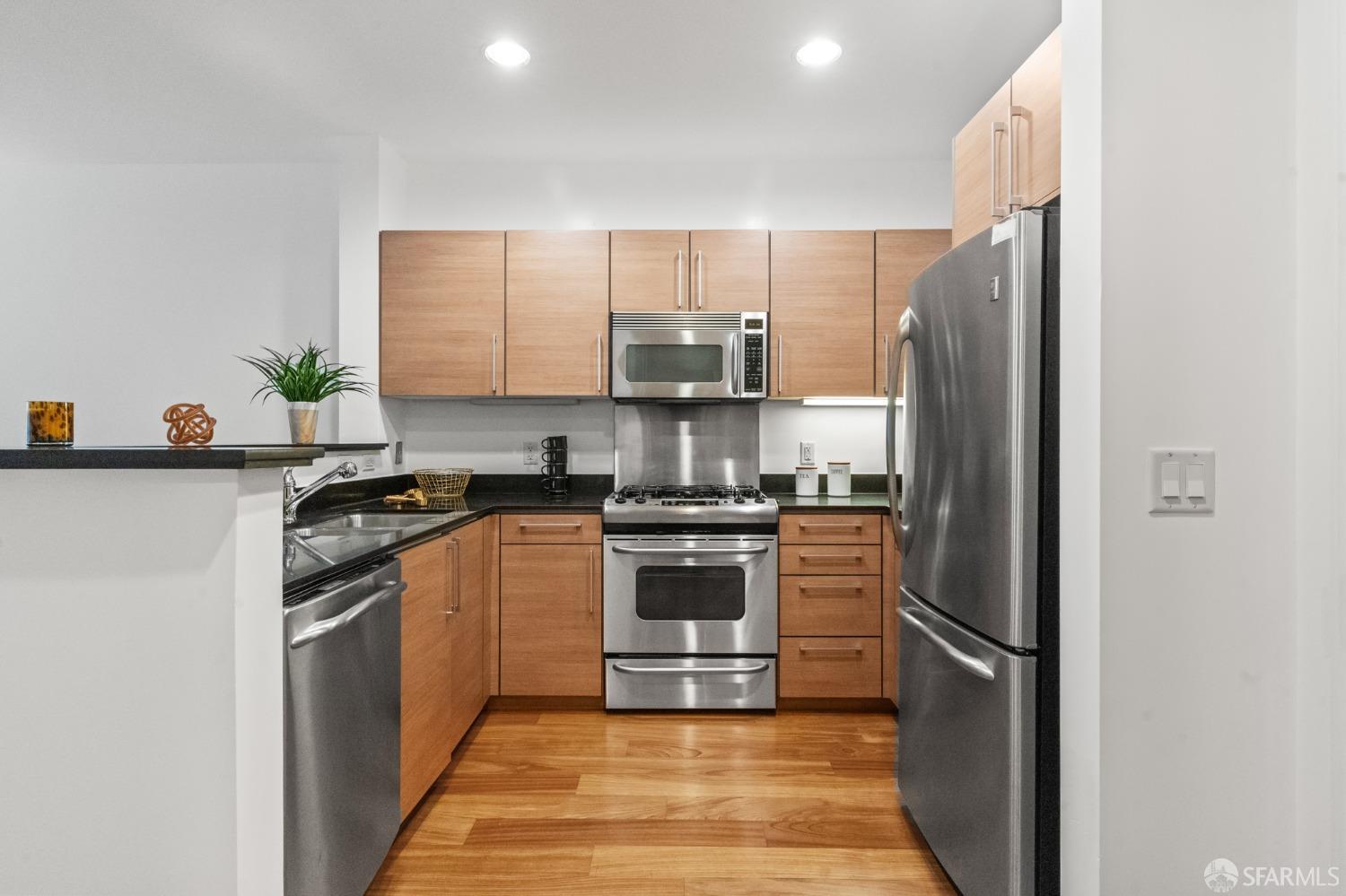 200 2nd Street, Unit 103 Oakland, CA 94607 - Photo 11 of 31 a kitchen with stainless steel appliances granite countertop a refrigerator stove and sink