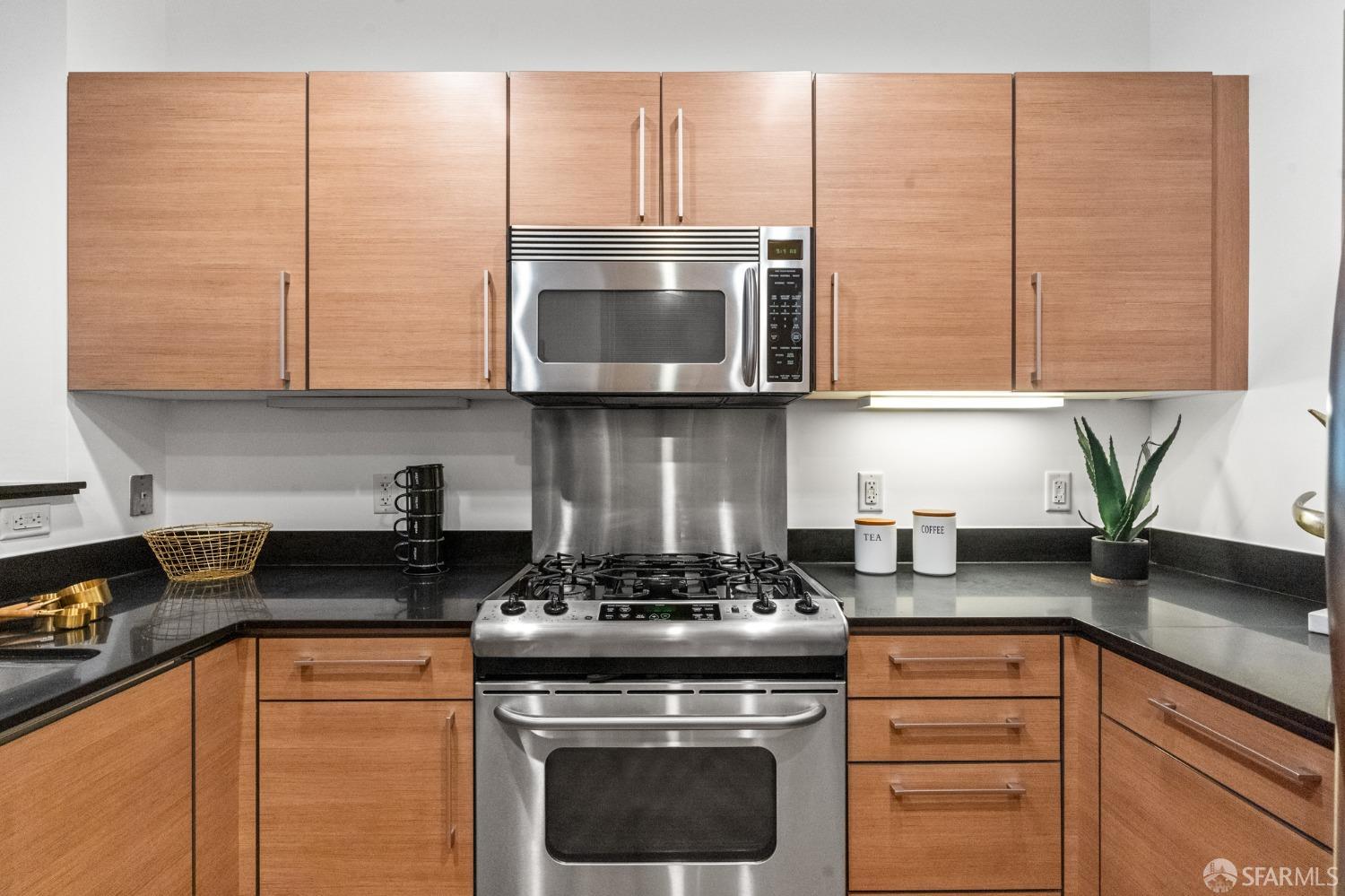 200 2nd Street, Unit 103 Oakland, CA 94607 - Photo 14 of 31 a kitchen with stainless steel appliances granite countertop white cabinets and a stove top oven