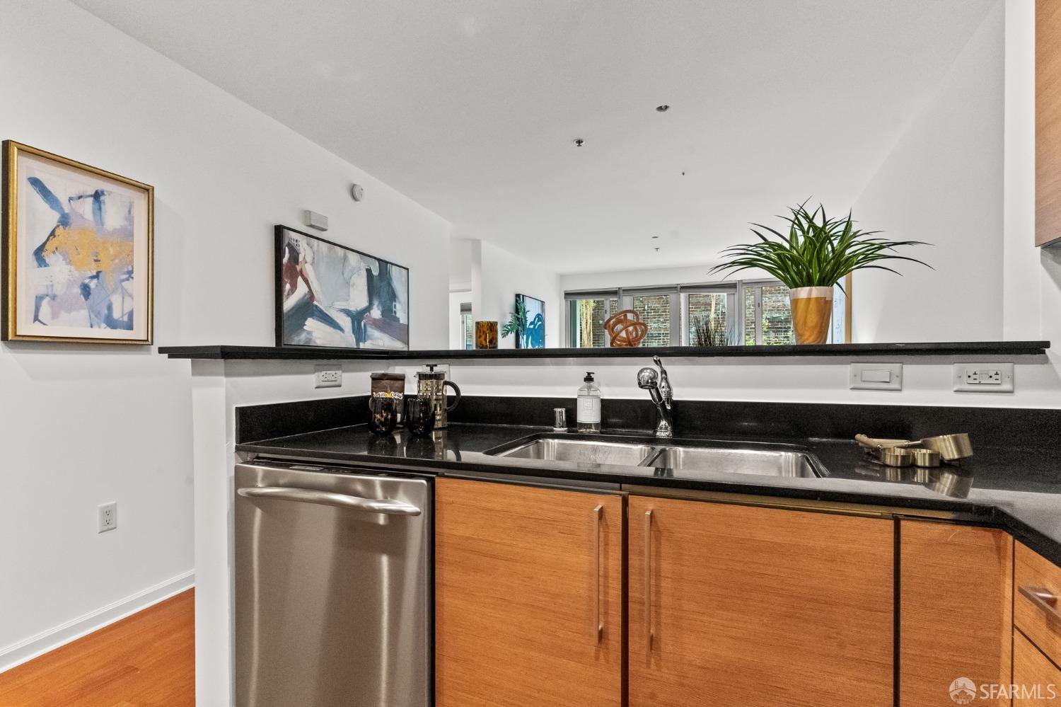 200 2nd Street, Unit 103 Oakland, CA 94607 - Photo 17 of 31 a kitchen with granite countertop a sink a refrigerator and cabinets