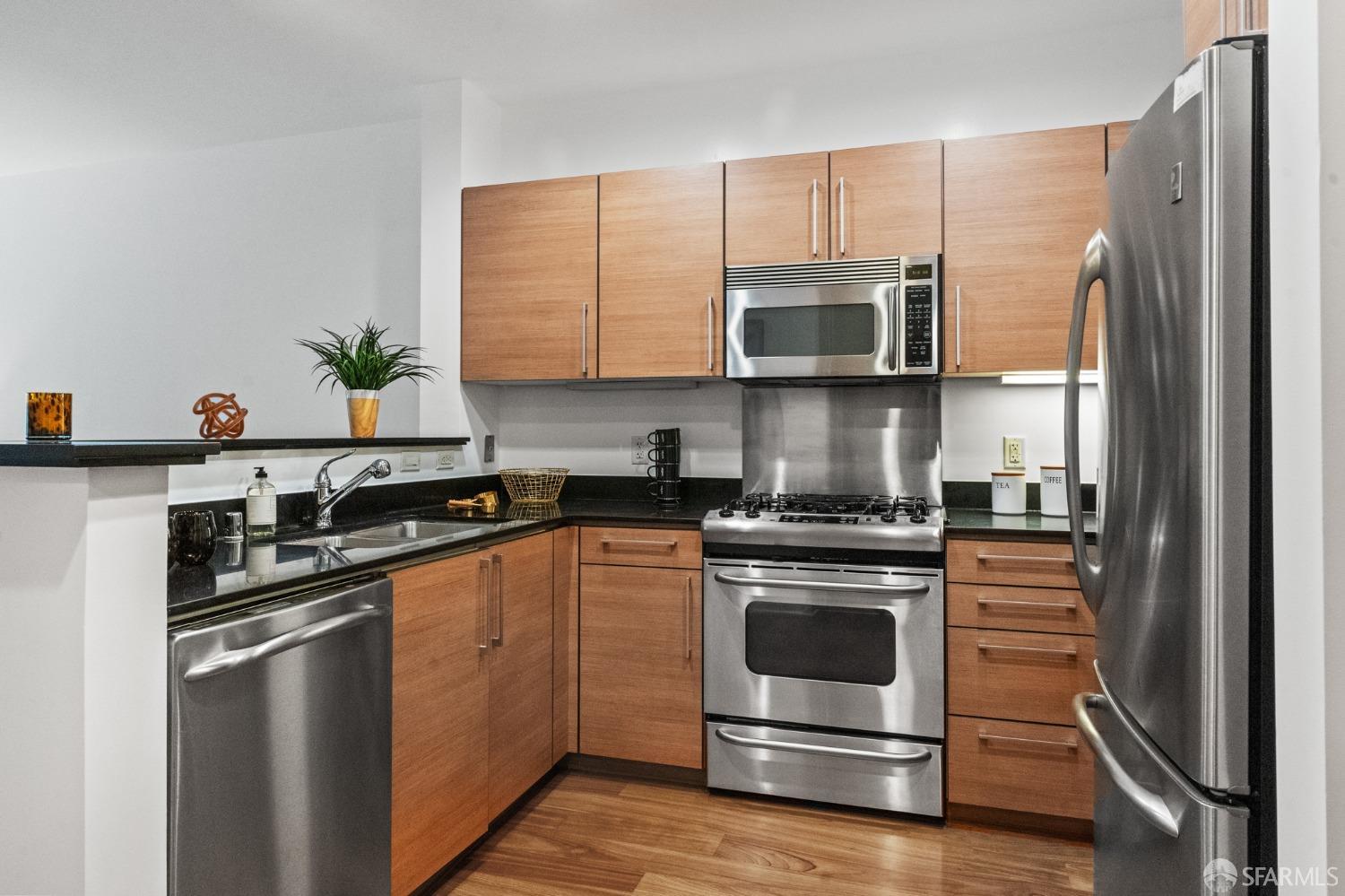200 2nd Street, Unit 103 Oakland, CA 94607 - Photo 2 of 31 a kitchen with stainless steel appliances a stove a sink and a refrigerator