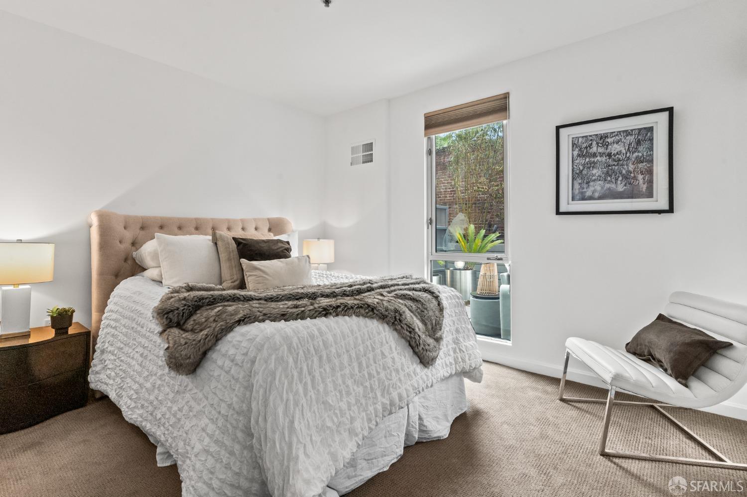 200 2nd Street, Unit 103 Oakland, CA 94607 - Photo 5 of 31 a bedroom with a bed and chair