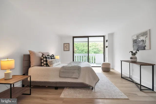 a bedroom with a bed a lamp and a large window