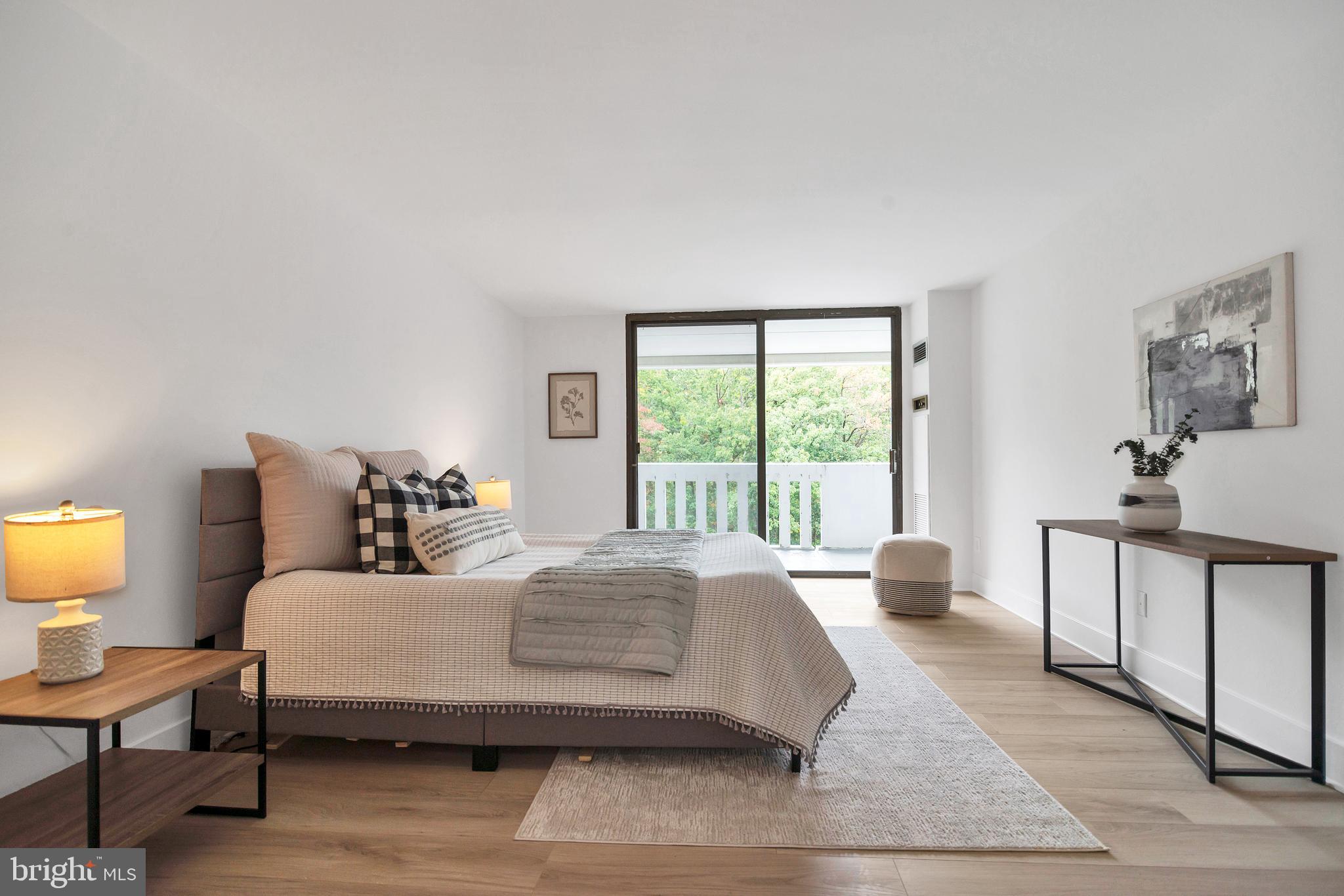 6101 Edsall Road, Unit 602 Alexandria, VA 22304 - Photo 12 of 31 a bedroom with a bed a lamp and a large window