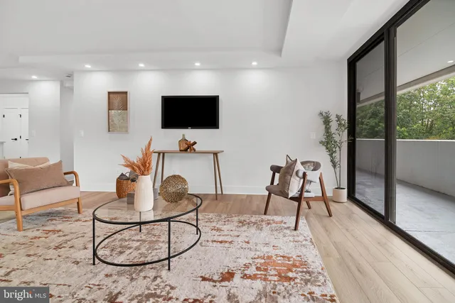 a living room with furniture a flat screen tv and a large window