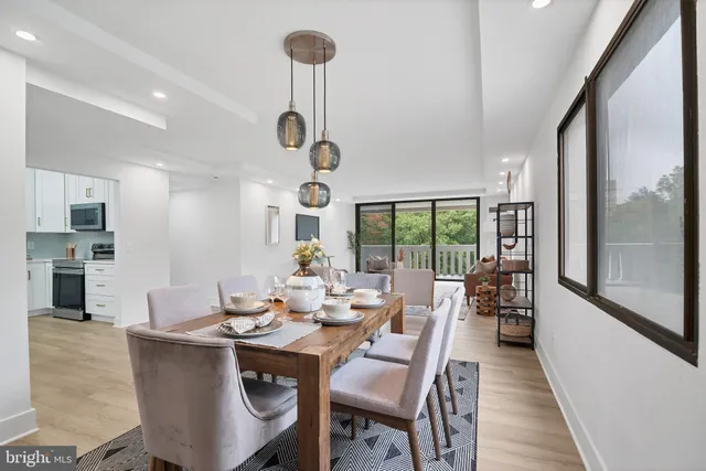 a dining room with furniture a chandelier and wooden floor
