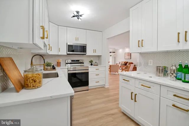 a kitchen with cabinets stainless steel appliances a sink and a stove