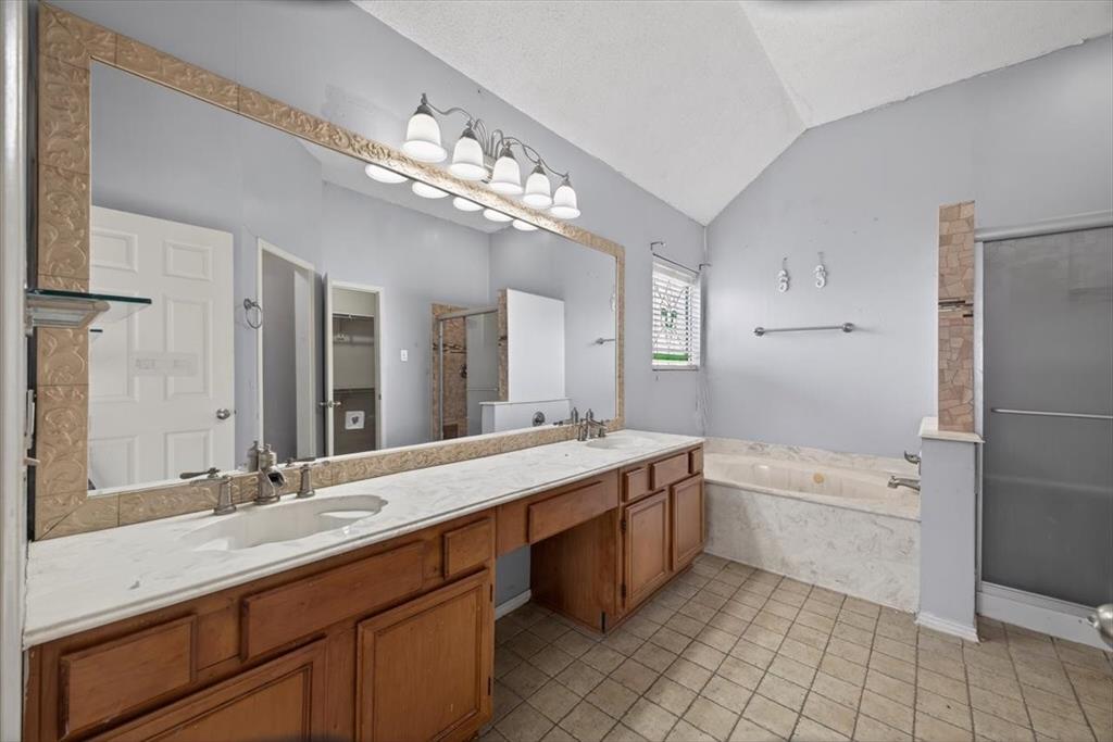 920 Danforth Place Arlington, TX 76017 - Photo 19 of 28 a bathroom with a granite countertop double vanity sink a mirror and a bathtub