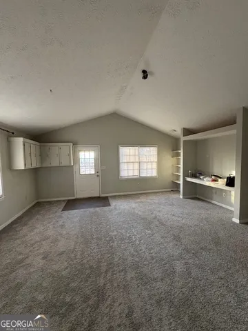 a view of an empty room with a window and fireplace