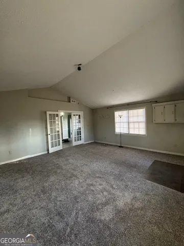 a view of a big room with windows and chandelier fan
