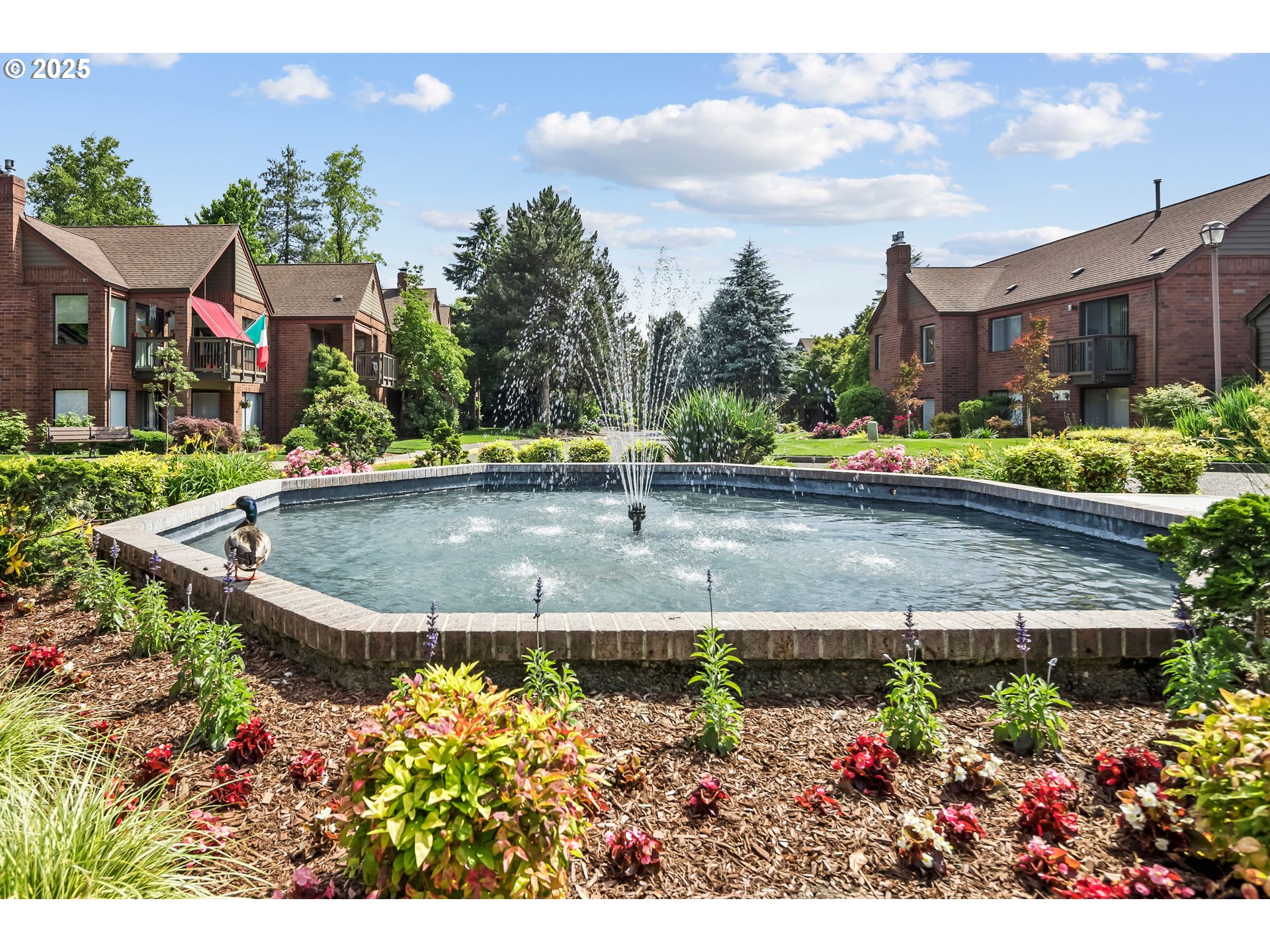 15565 Southwest 114th Court, Unit 26 Portland, OR 97224 - Photo 24 of 32 a view of a house with a garden and a pond