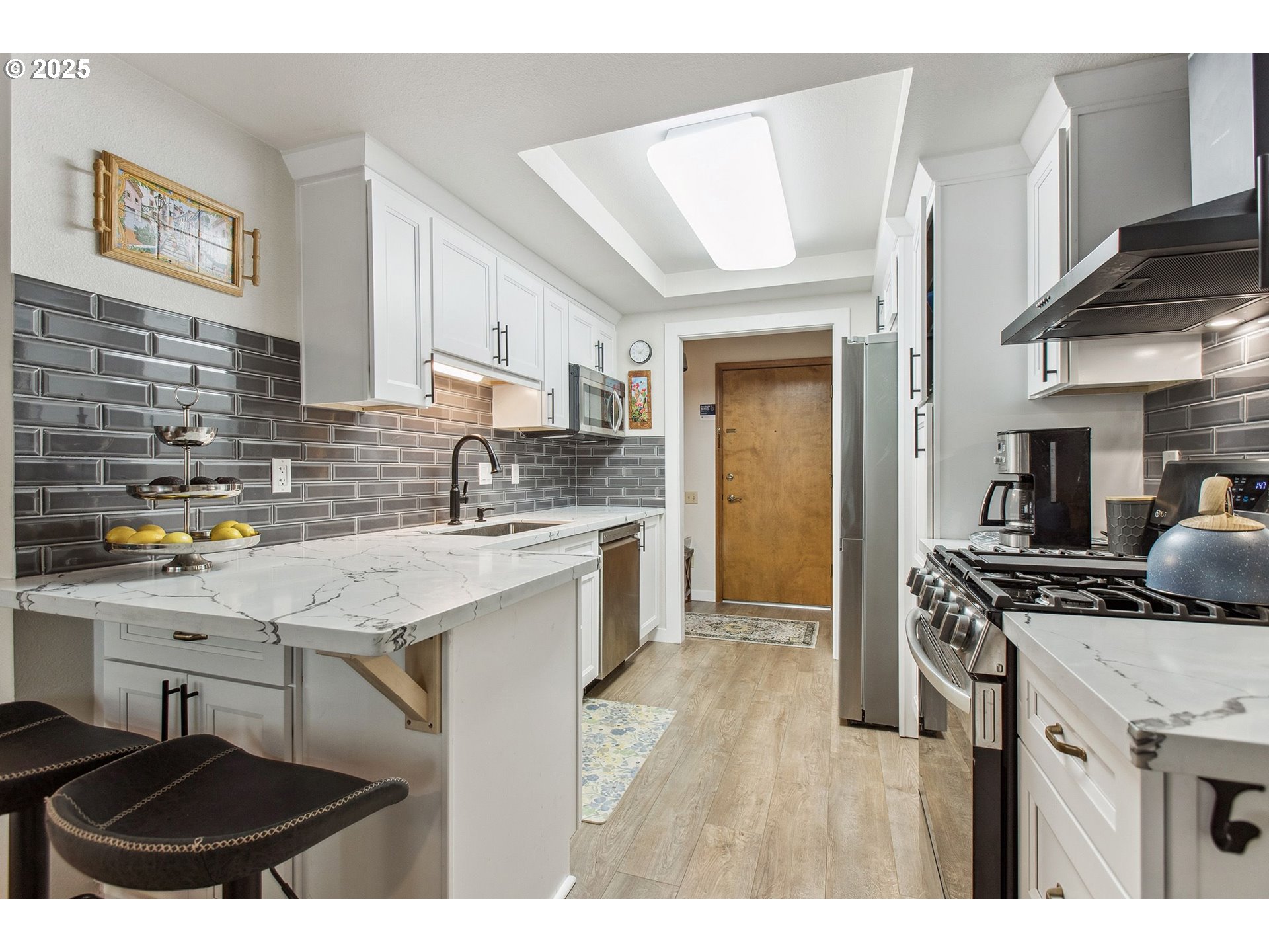 15565 Southwest 114th Court, Unit 26 Portland, OR 97224 - Photo 6 of 32 a kitchen with stainless steel appliances a sink a stove a refrigerator cabinets and a dining table