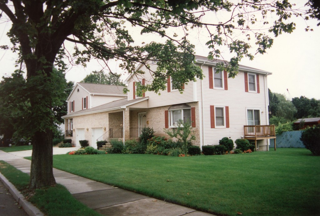 a front view of a house with a garden and yard
