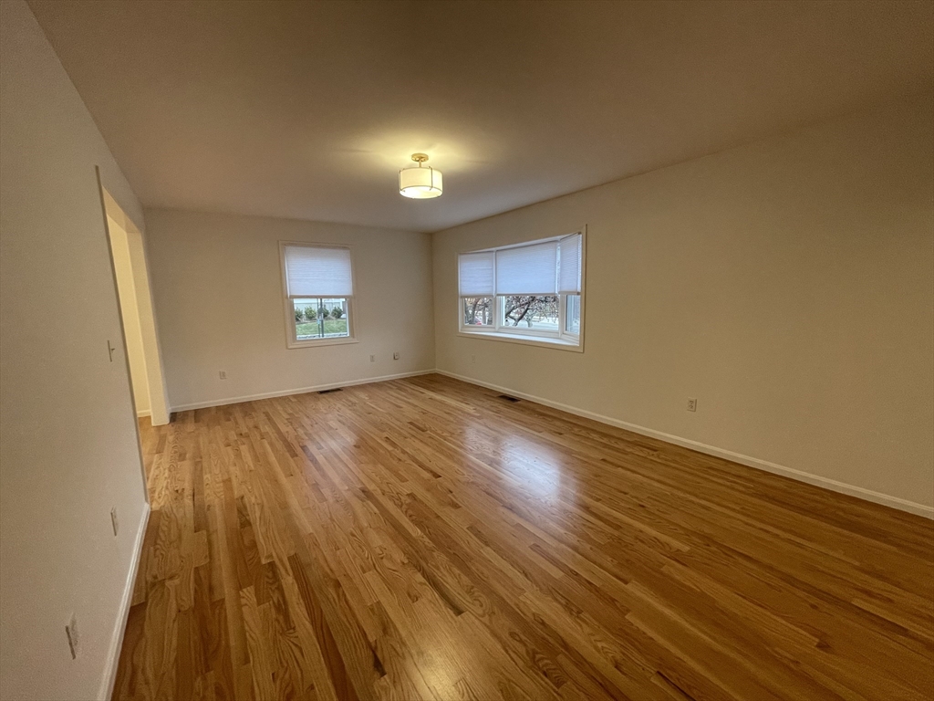 196 Linwood Avenue, Unit 196 Newton, MA 02460 - Photo 15 of 37 an empty room with wooden floor and windows