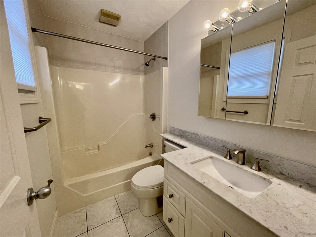 196 Linwood Avenue, Unit 196 Newton, MA 02460 - Photo 21 of 37 a bathroom with a granite countertop sink toilet and shower