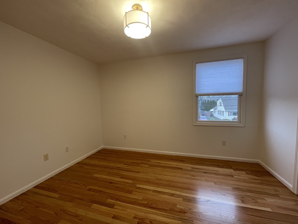 196 Linwood Avenue, Unit 196 Newton, MA 02460 - Photo 22 of 37 a view of an empty room with wooden floor and a window