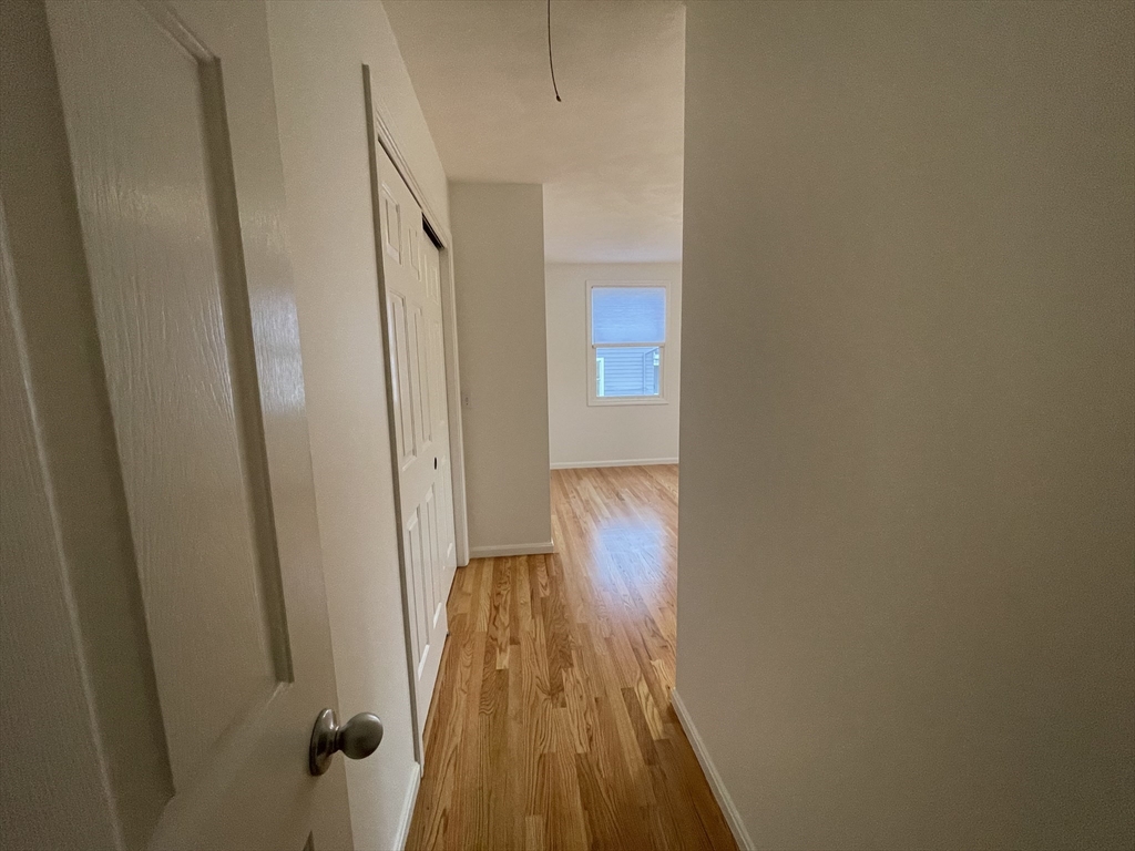196 Linwood Avenue, Unit 196 Newton, MA 02460 - Photo 25 of 37 a view of a hallway with wooden floor and staircase