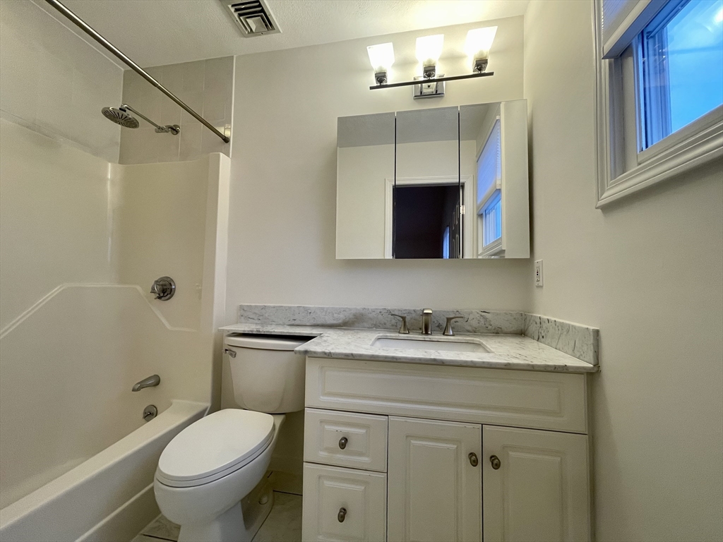 196 Linwood Avenue, Unit 196 Newton, MA 02460 - Photo 31 of 37 a bathroom with a granite countertop sink toilet and shower