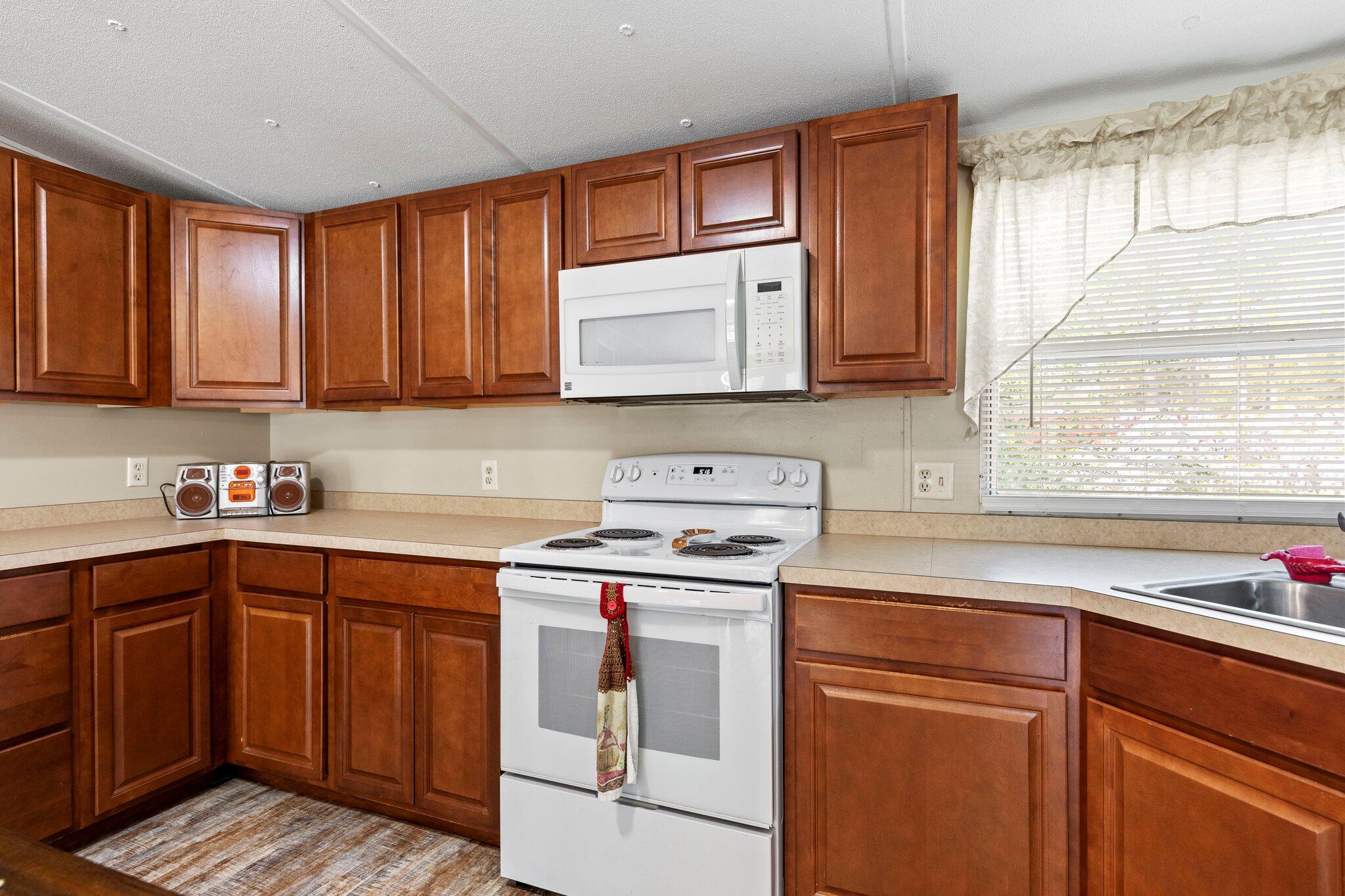 3062 Highland Avenue Crestview, FL 32539 - Photo 20 of 58 a kitchen with stainless steel appliances granite countertop wooden cabinets a sink and a window