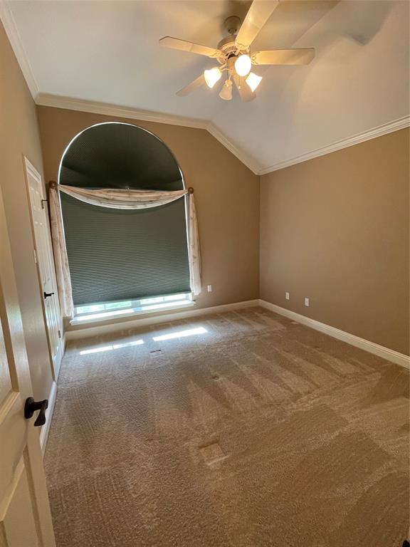 1035 Crouch Road Benton, LA 71006 - Photo 7 of 9 Vaulted ceiling with crown molding, arched window, ceiling fan with integrated lighting, and neutral carpeting