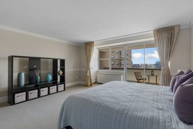 a bedroom with a bed and large windows