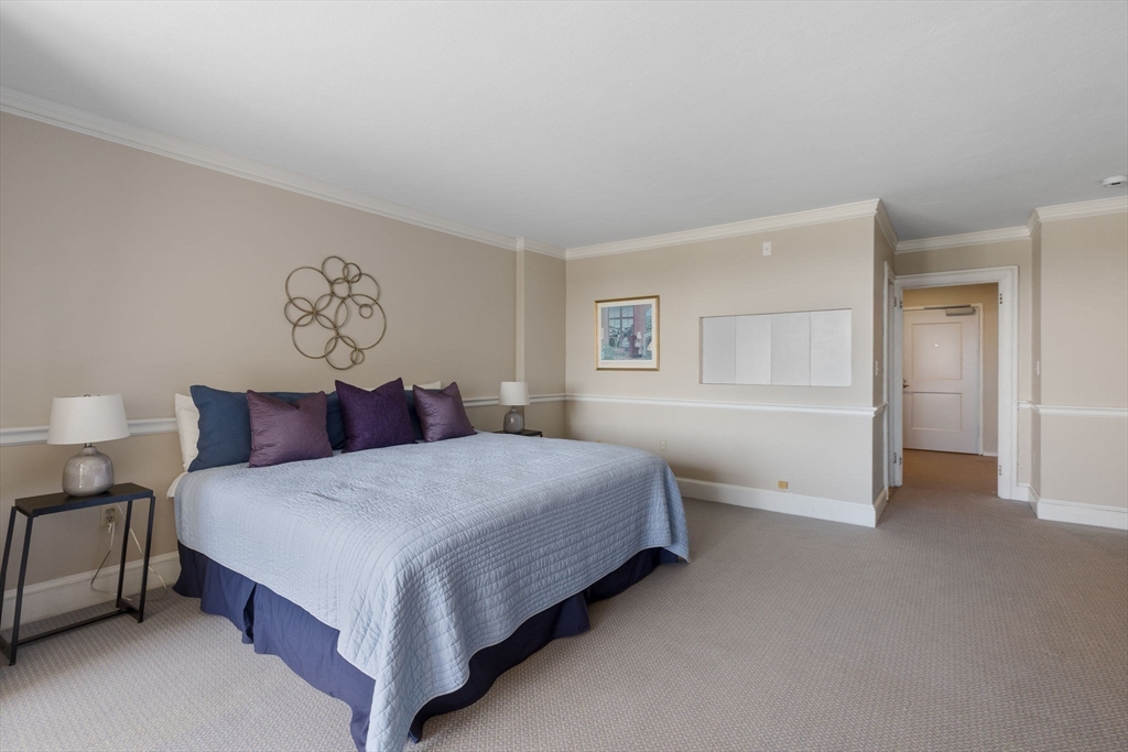 6 Whittier Place, Unit 14N&O Boston, MA 02114 - Photo 19 of 31 a bedroom with a bed and a night stand