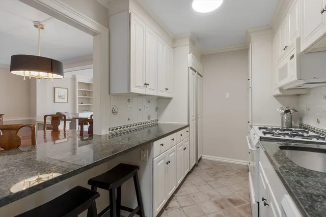 a kitchen with granite countertop a sink a stove and a wooden cabinets