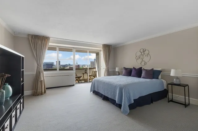 a spacious bedroom with a bed couch and a window