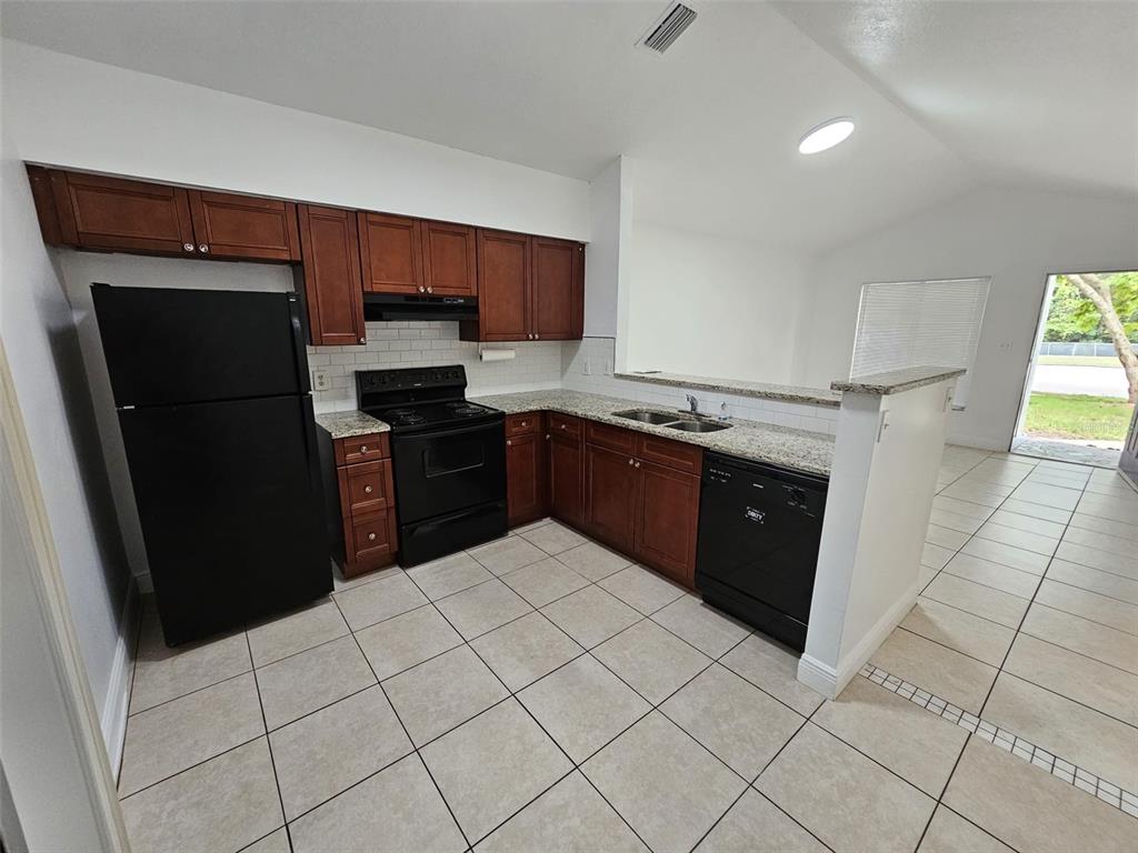 10481 Riva Ridge Trail Orlando, FL 32817 - Photo 2 of 9 a kitchen with stainless steel appliances granite countertop a refrigerator and a sink