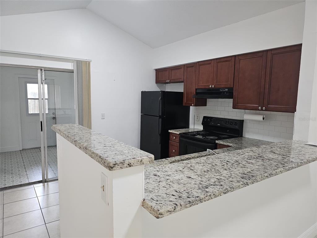 10481 Riva Ridge Trail Orlando, FL 32817 - Photo 3 of 9 a kitchen with stainless steel appliances granite countertop a sink stove and refrigerator