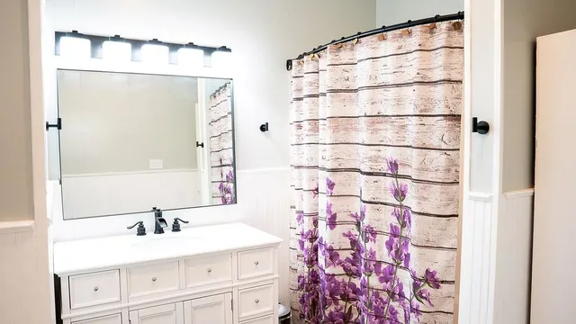 a bathroom with a toilet and a shower curtain