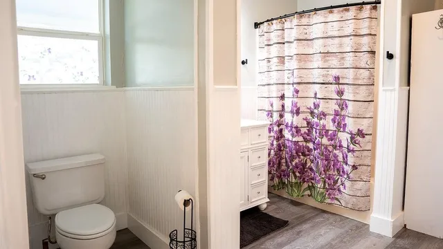 a bathroom with a toilet and a shower curtain