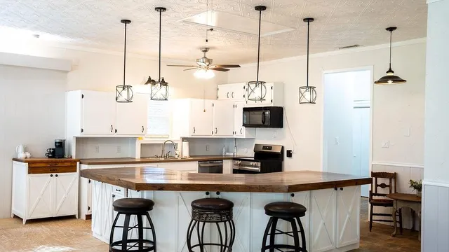 a kitchen with stainless steel appliances granite countertop a sink a stove and a wooden floor