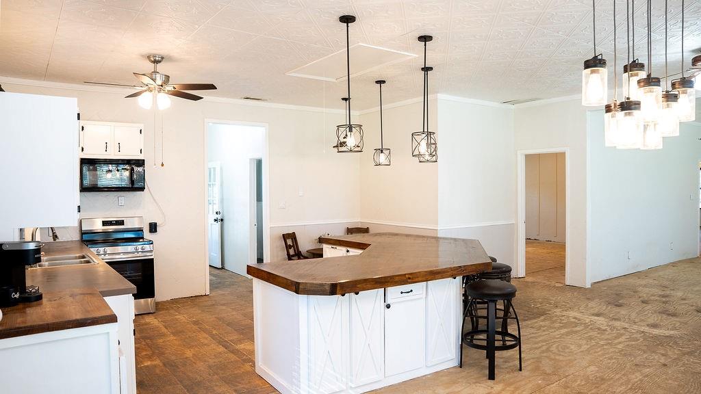 213 County Road 2320 Telephone, TX 75488 - Photo 5 of 40 a kitchen with a refrigerator a stove and a sink with wooden floor