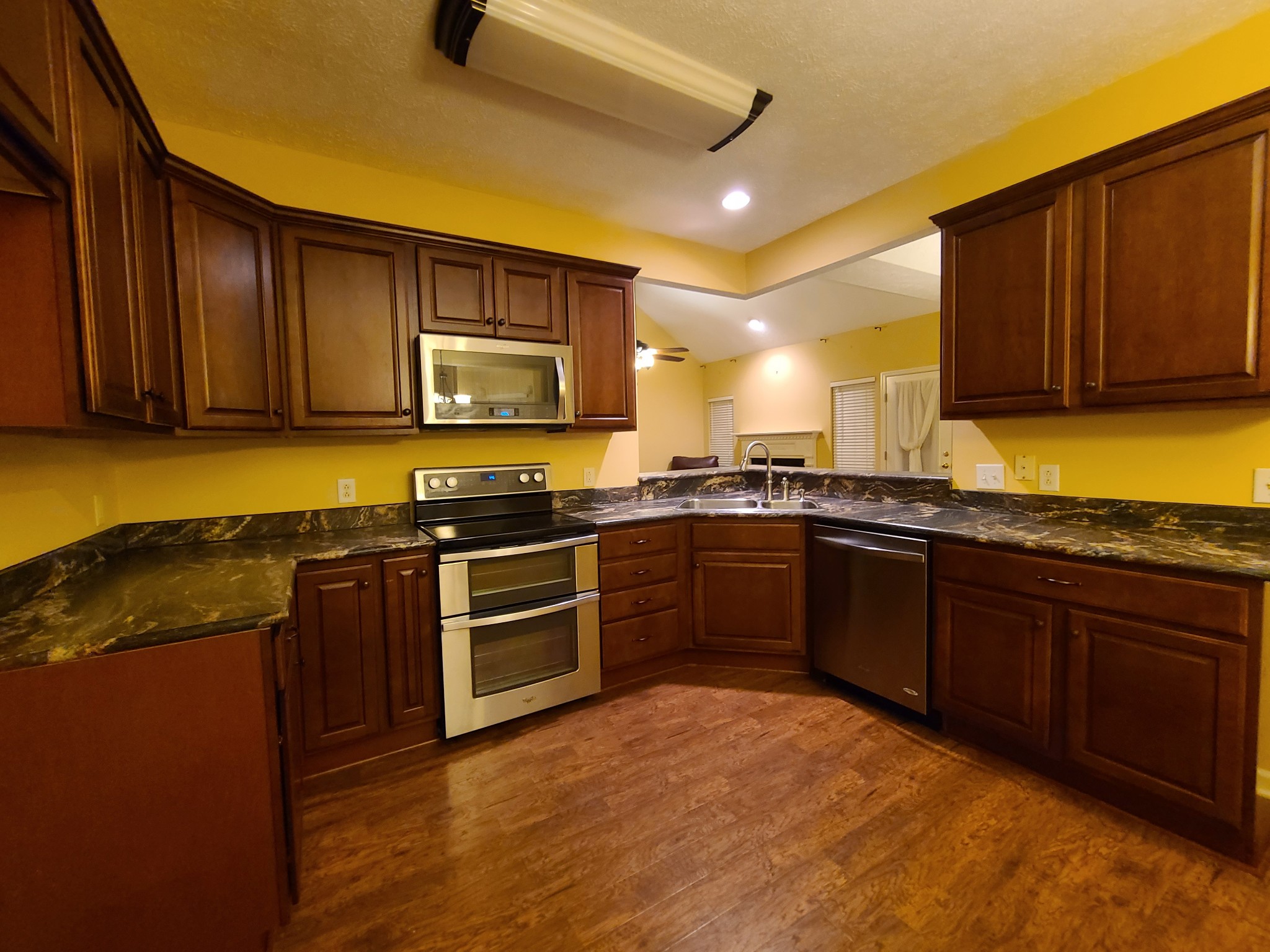 728 Canoe Ridge Point Antioch, TN 37013 - Photo 12 of 40 a kitchen with stainless steel appliances granite countertop wooden cabinets a stove top oven a sink and dishwasher