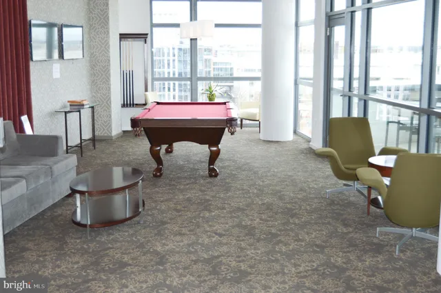 a living room with furniture and a floor to ceiling window