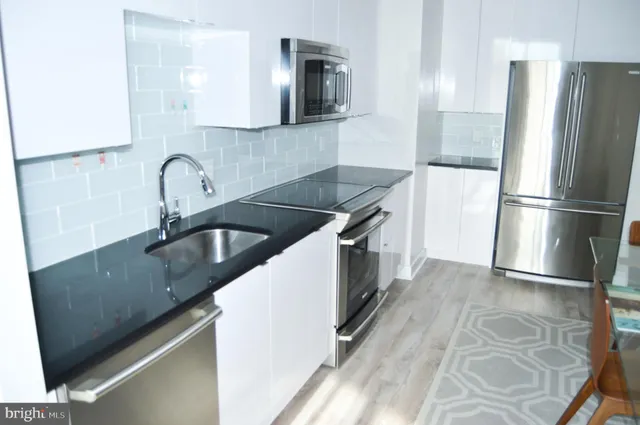 a kitchen with granite countertop a sink stove and refrigerator