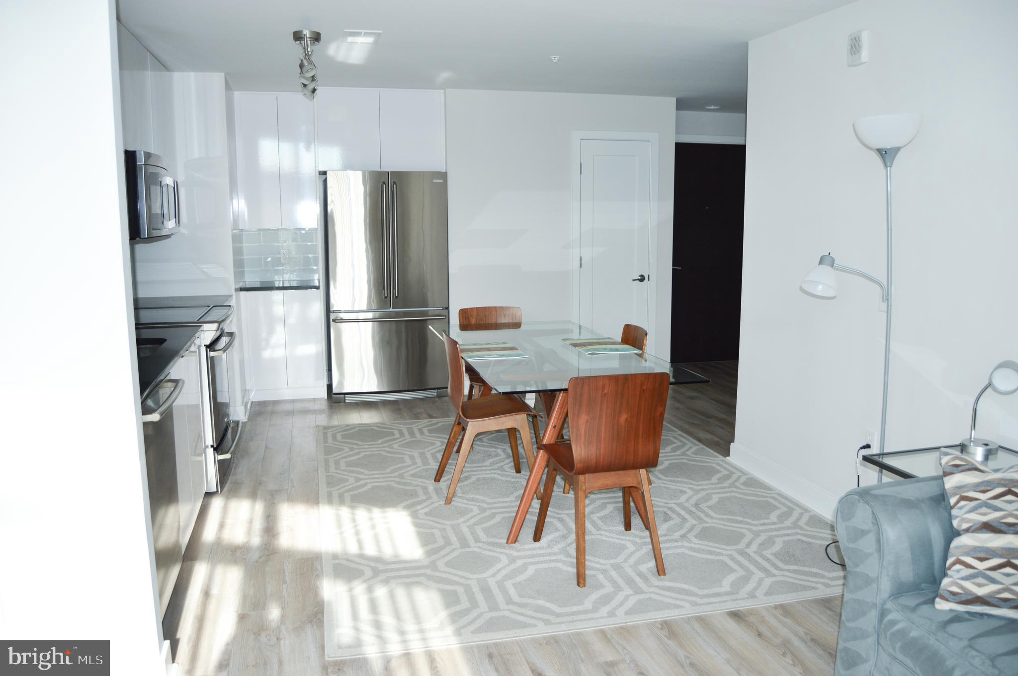 460 New York Avenue Northwest, Unit 805 Washington, DC 20001 - Photo 7 of 21 a kitchen with stainless steel appliances kitchen island granite countertop furniture and a refrigerator