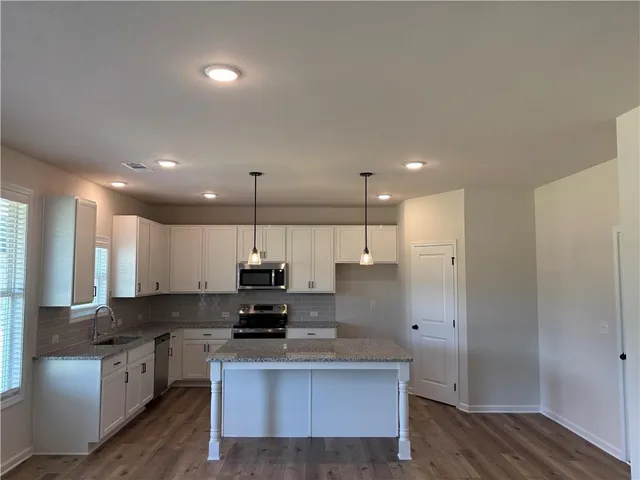 a kitchen with kitchen island a sink and a stove top oven